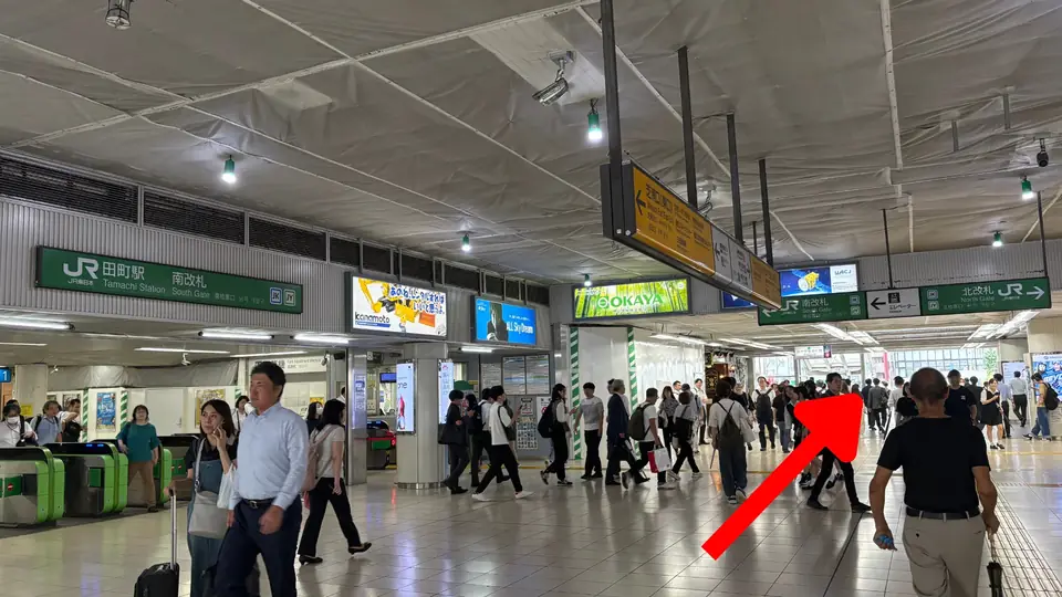JR田町駅の南改札を出て三田口方面へ進む様子（矢印は進行方向）